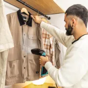 Demonstração do ferro vertical IronHero a passar uma camisa diretamente no cabide.